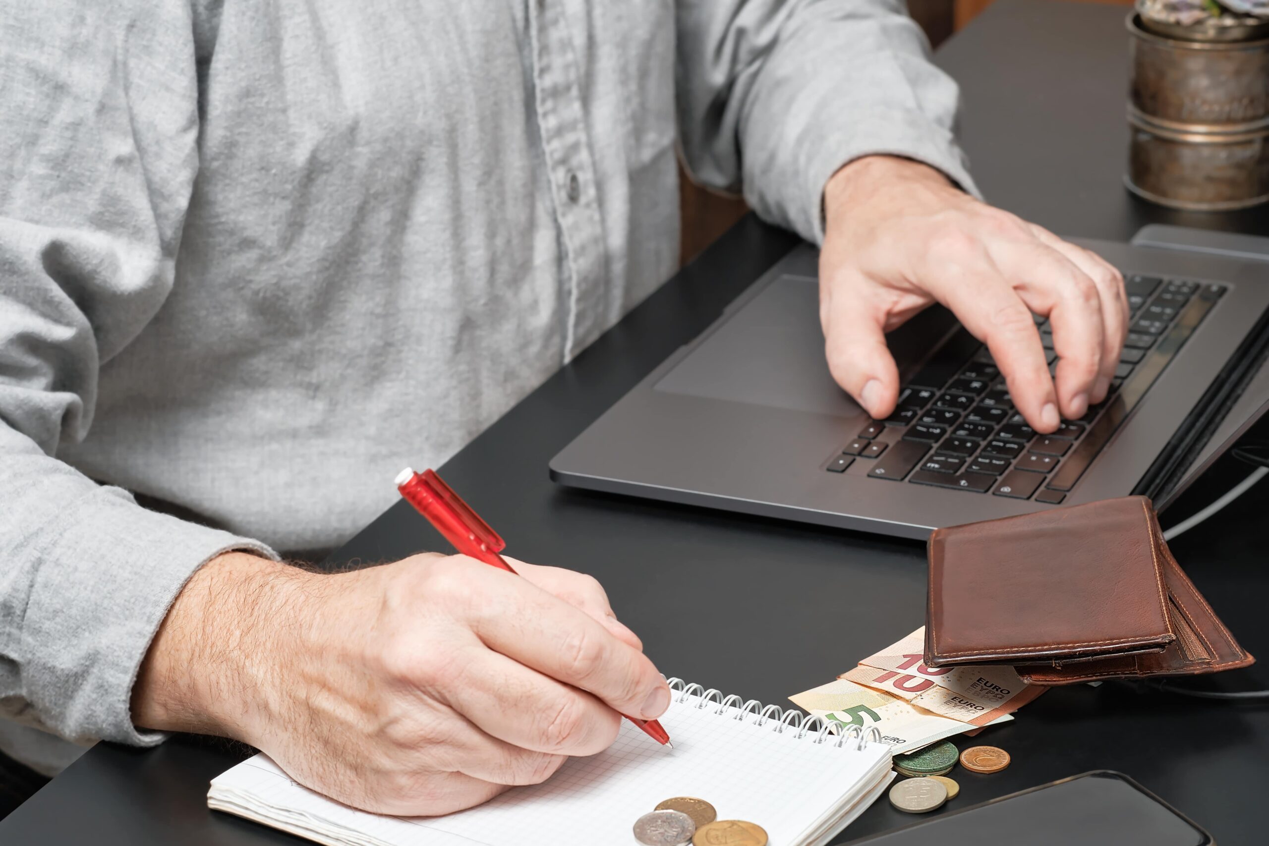 businessman accountant holding pen working desk using laptop calculate financial report min