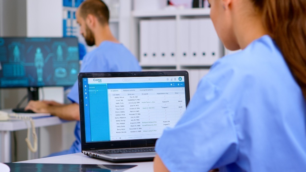 professional doctor assistant checking medical records laptop with x ray medical equipment around physician working hospital clinic making appointments analysing patient registration