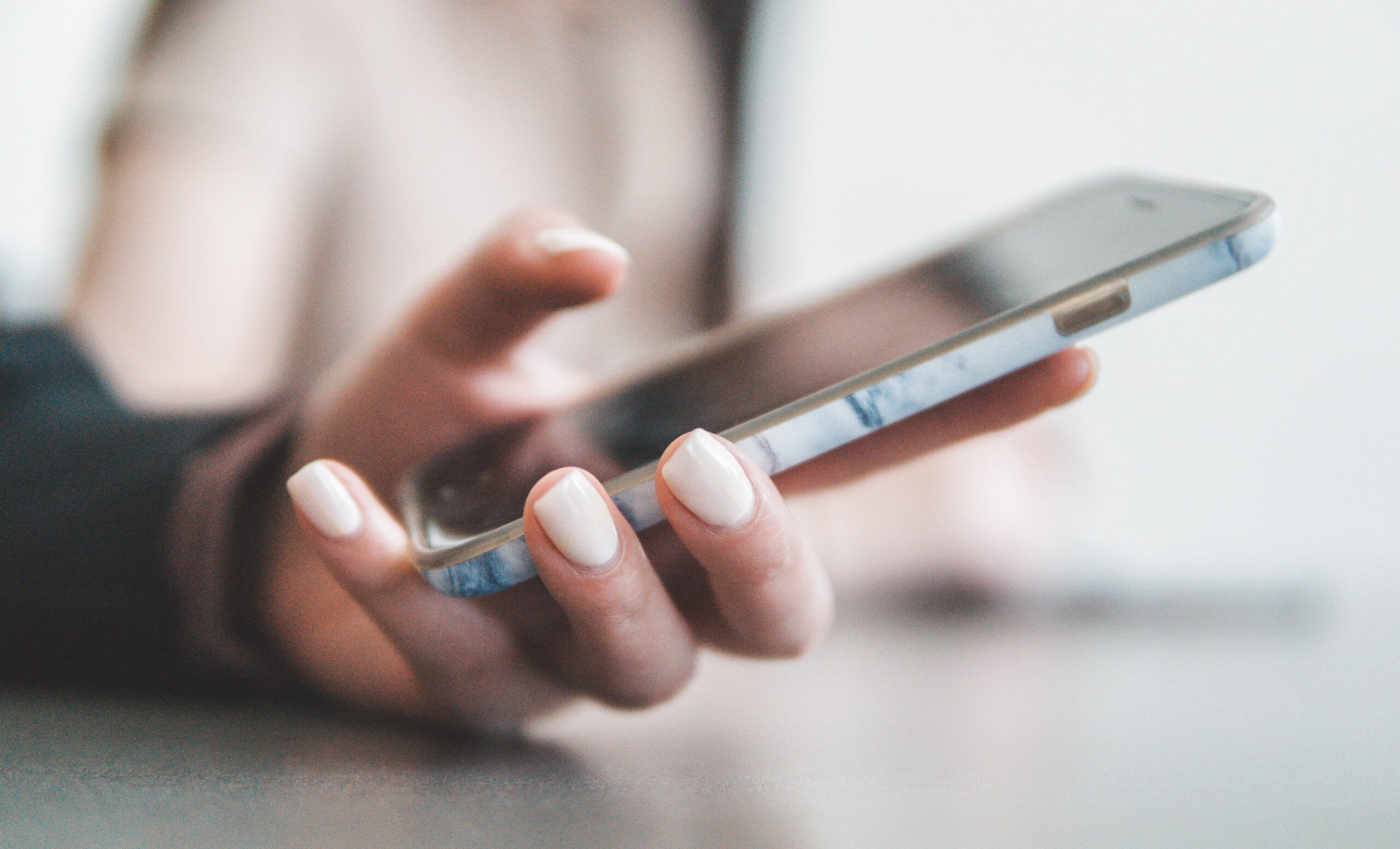  a person holding a phone to use voice brandname service
