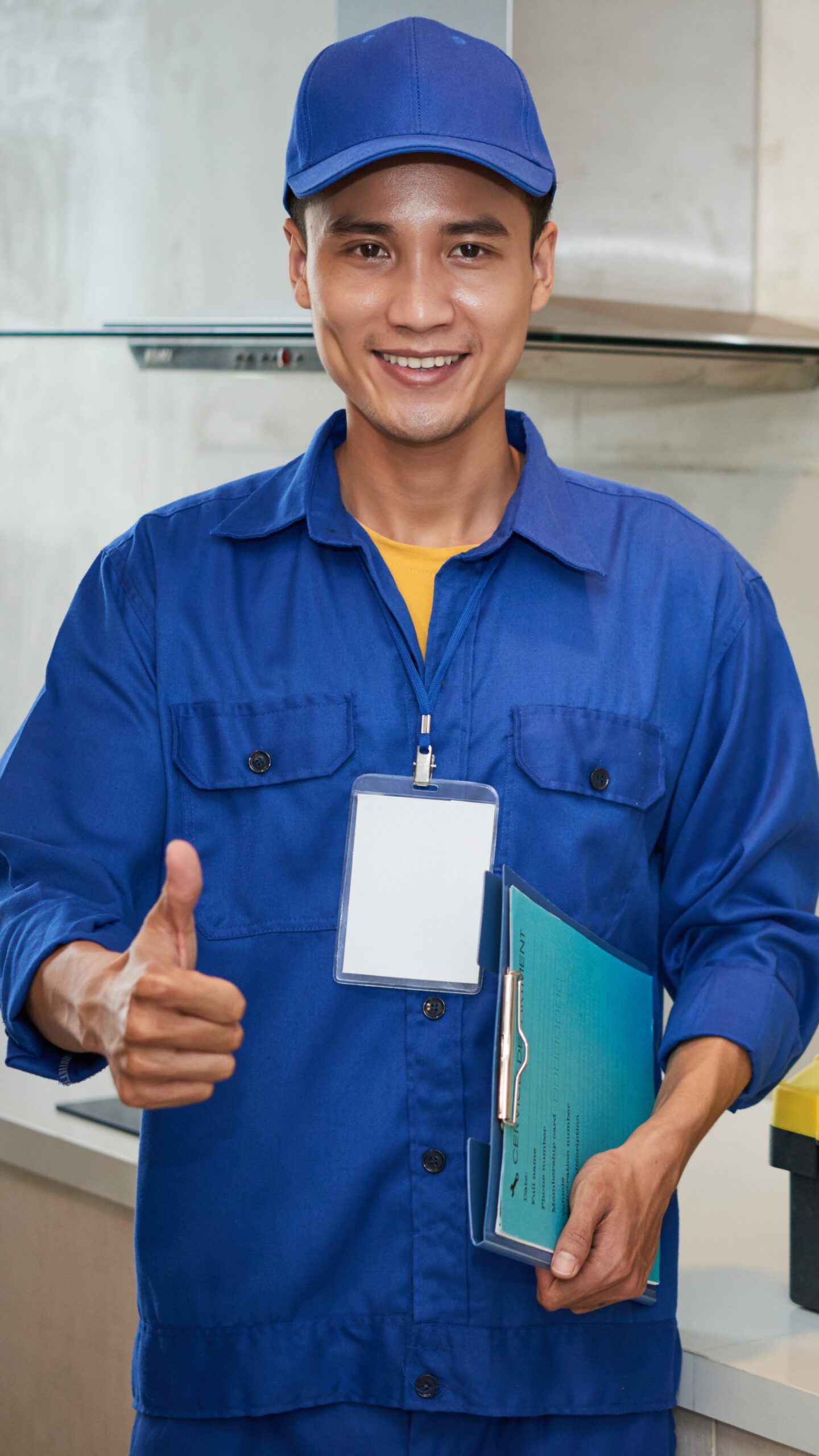Portrait of happy young repairman in kitchen